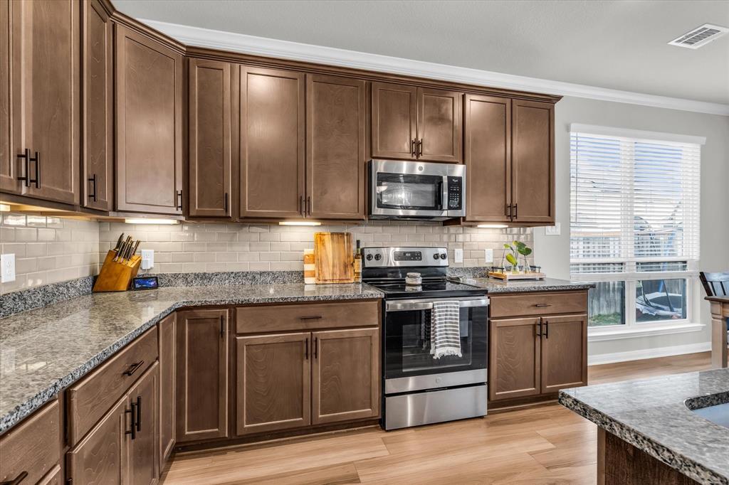 7008 Llano Drive China Spring, TX 76633 - Photo 9 of 26 a kitchen with stainless steel appliances granite countertop a stove a sink and a microwave