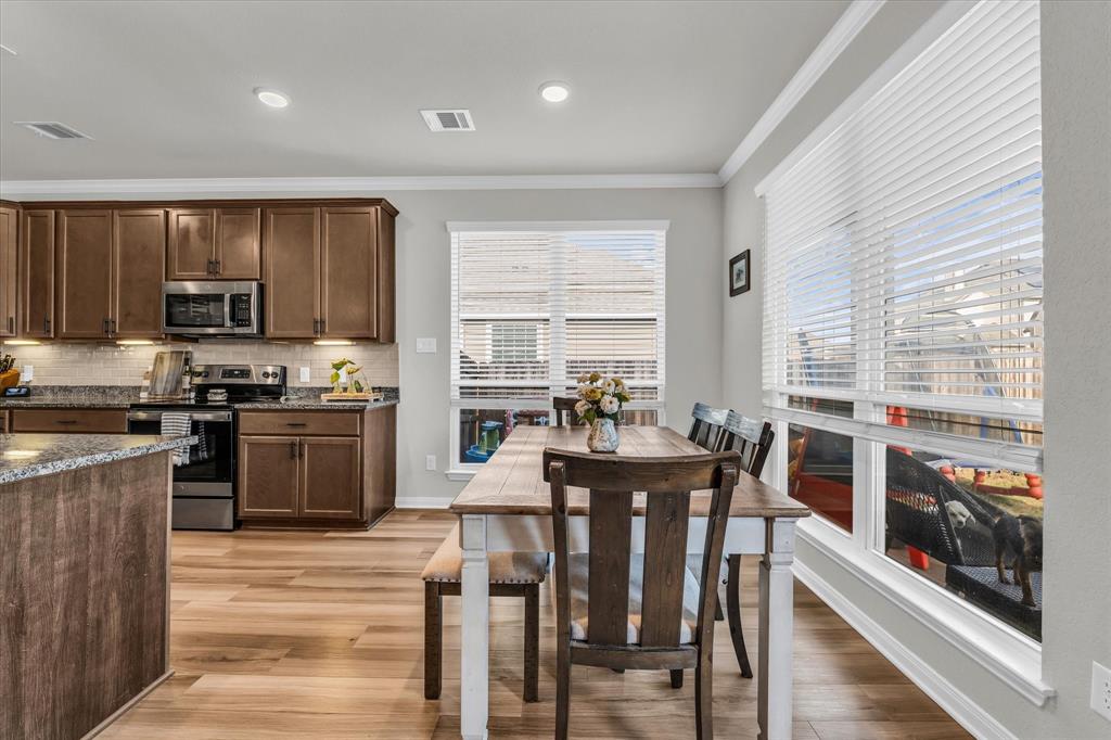 7008 Llano Drive China Spring, TX 76633 - Photo 10 of 26 a kitchen with stainless steel appliances kitchen island granite countertop a stove a refrigerator a dining table and chairs
