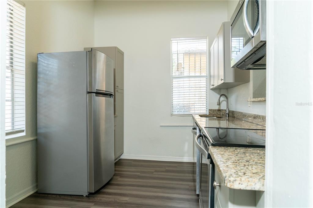2906 West Chestnut Street, Unit 2 Tampa, FL 33607 - Photo 24 of 28 a kitchen with stainless steel appliances granite countertop a sink stove and refrigerator