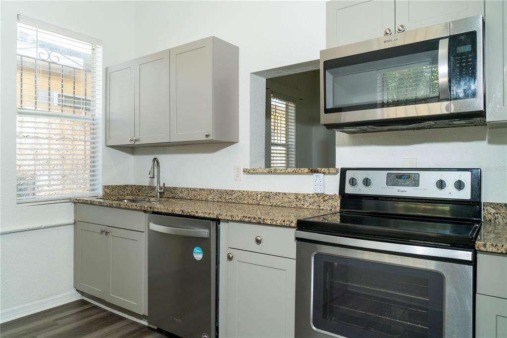 2906 West Chestnut Street, Unit 2 Tampa, FL 33607 - Photo 25 of 28 a kitchen with granite countertop a stove microwave and sink