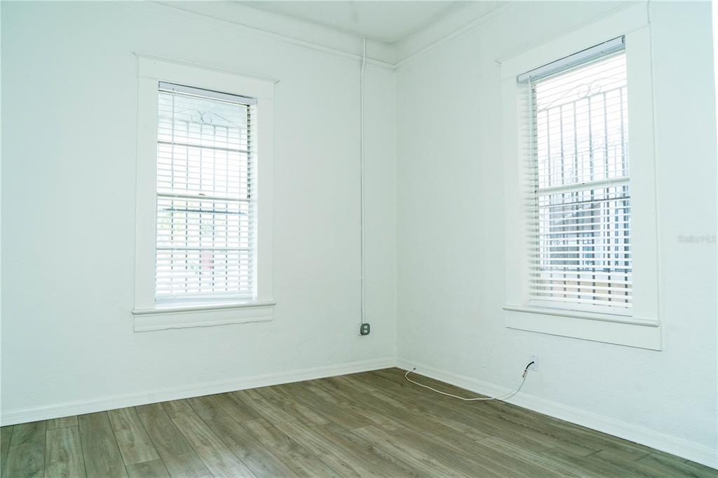 2906 West Chestnut Street, Unit 2 Tampa, FL 33607 - Photo 5 of 28 an empty room with wooden floor and windows