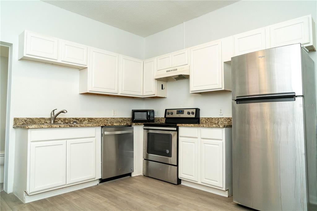 2906 West Chestnut Street, Unit 2 Tampa, FL 33607 - Photo 7 of 28 a kitchen with a white cabinets and white appliances