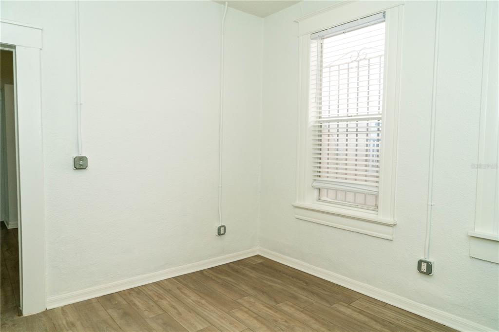 2906 West Chestnut Street, Unit 2 Tampa, FL 33607 - Photo 10 of 28 an empty room with wooden floor and windows