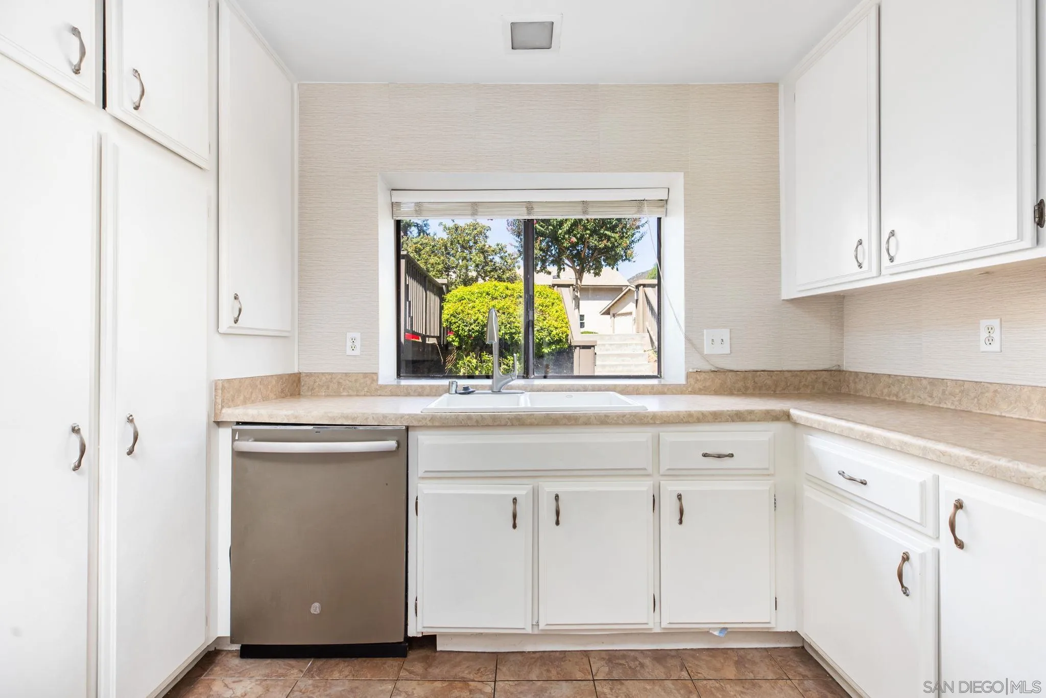 4121 Oak Island Lane Fallbrook, CA 92028 - Photo 8 of 25 a kitchen with granite countertop white cabinets and a window