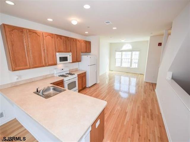 36 Chelsea Court, Unit 36 Atlantic City, NJ 08401 - Photo 6 of 23 a kitchen with wooden floors and wooden cabinets