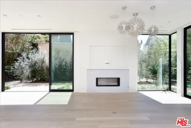 a living room with a fireplace and large windows