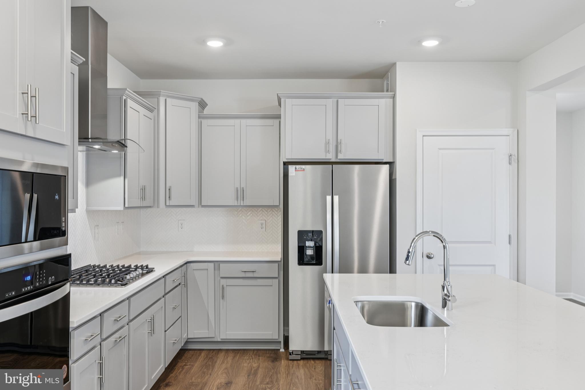 470 Herringbone Way Frederick, MD 21701 - Photo 24 of 61 a kitchen with stainless steel appliances granite countertop a refrigerator sink and cabinets