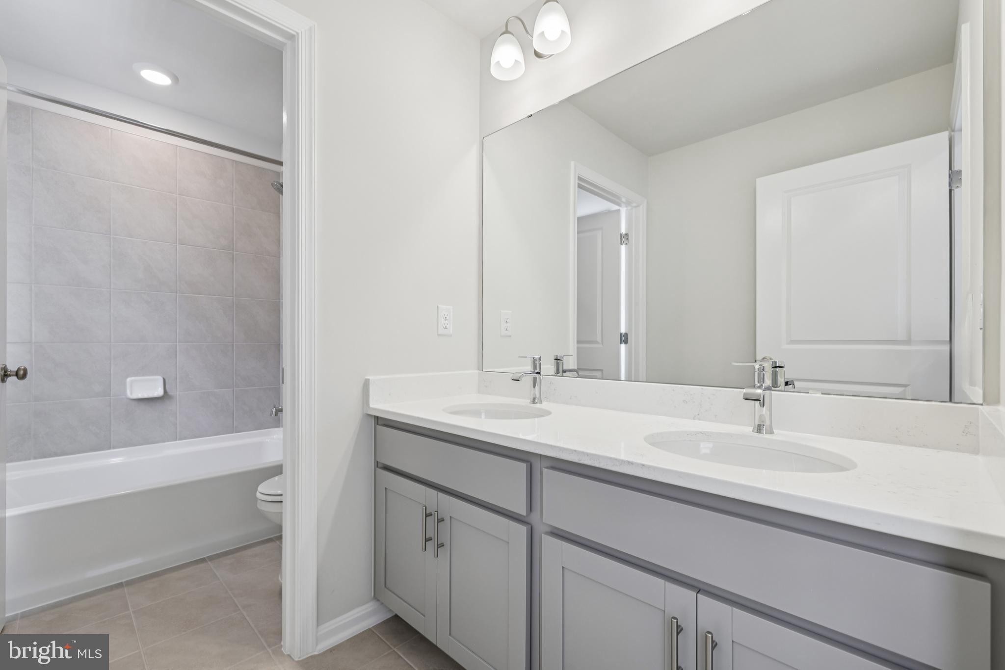 470 Herringbone Way Frederick, MD 21701 - Photo 36 of 61 a bathroom with a double vanity sink a mirror and a bathtub
