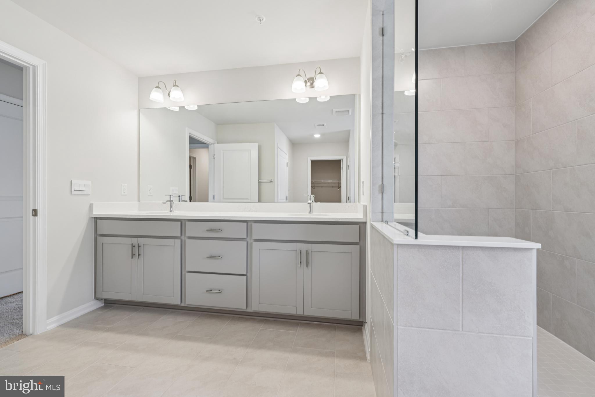 470 Herringbone Way Frederick, MD 21701 - Photo 49 of 61 a spacious bathroom with a granite countertop sink mirror and a