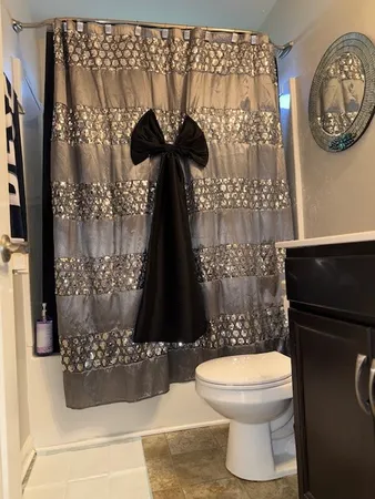 a bathroom with a toilet and a shower curtain