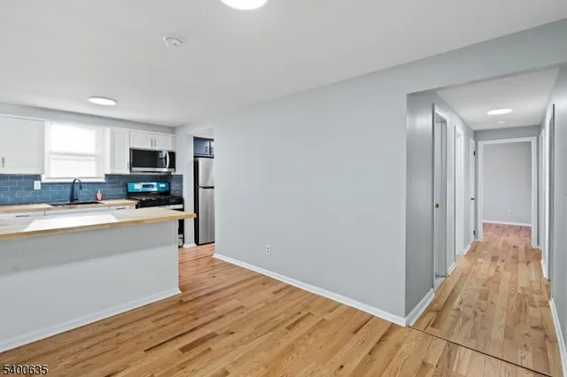 a large kitchen with wooden floor and stainless steel appliances