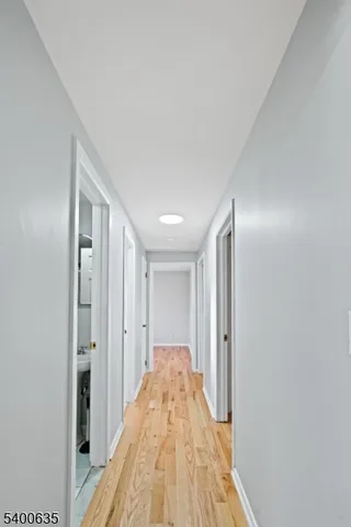 a view of a hallway with wooden floor and closet