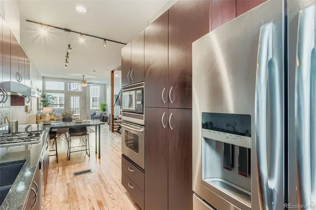 a kitchen with stainless steel appliances granite countertop a refrigerator and a stove