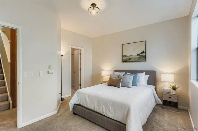 a bedroom with a bed and a painting on the wall