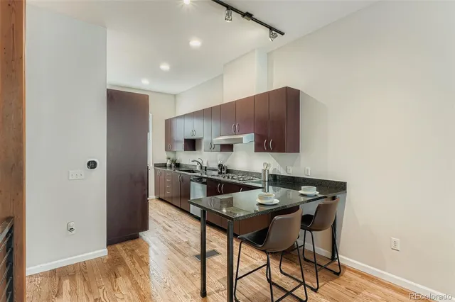 a kitchen with stainless steel appliances a stove a refrigerator and a microwave