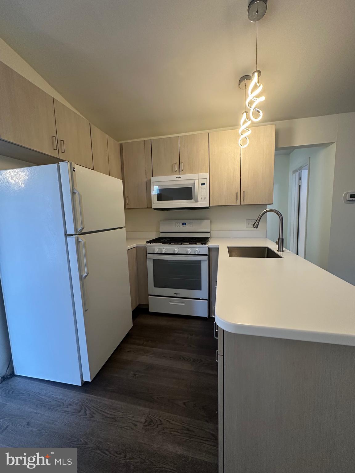 2300 South 12th Street, Unit 1 Philadelphia, PA 19148 - Photo 3 of 19 a kitchen with wooden cabinets and white appliances