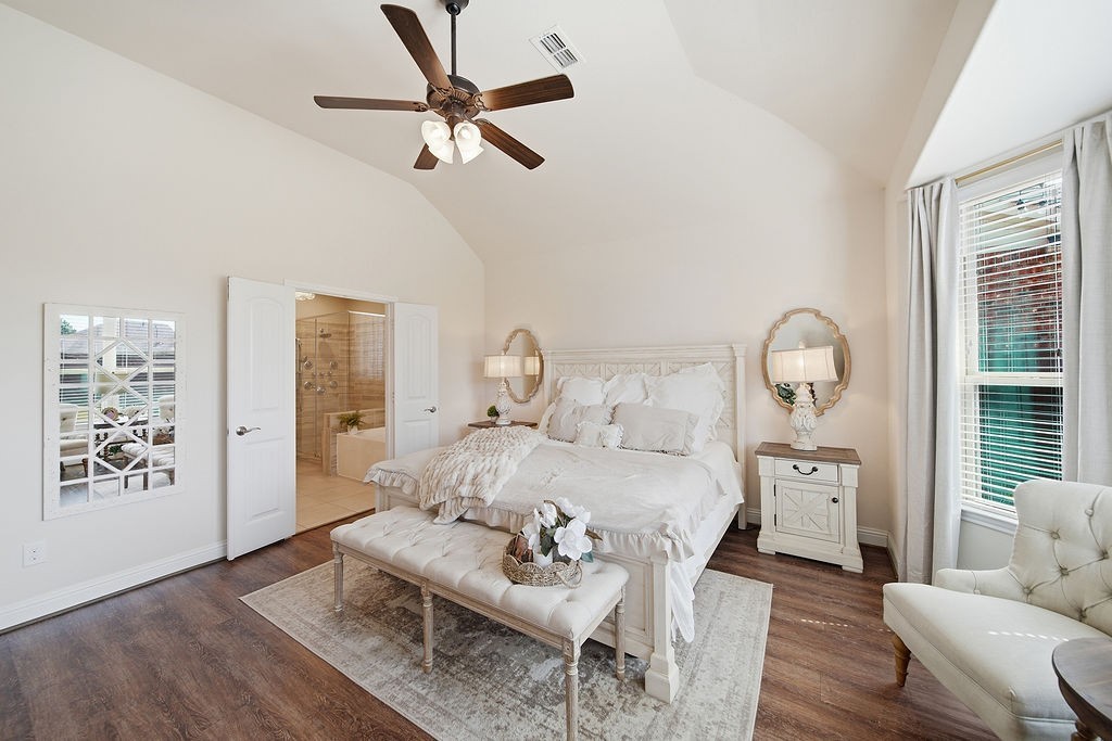9614 Carson Lane Iowa Colony, TX 77583 - Photo 21 of 50 Bright, inviting bedroom with rich wood floors, a cozy sitting area framed by a bay window, elegant lighting, and direct access to a beautifully updated en-suite bath.