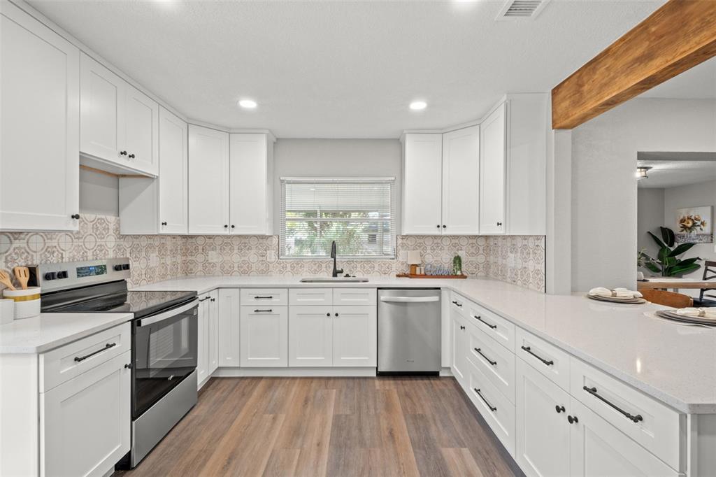 1472 Ruth Road Dunedin, FL 34698 - Photo 11 of 50 a kitchen with granite countertop white cabinets stainless steel appliances a sink and a stove