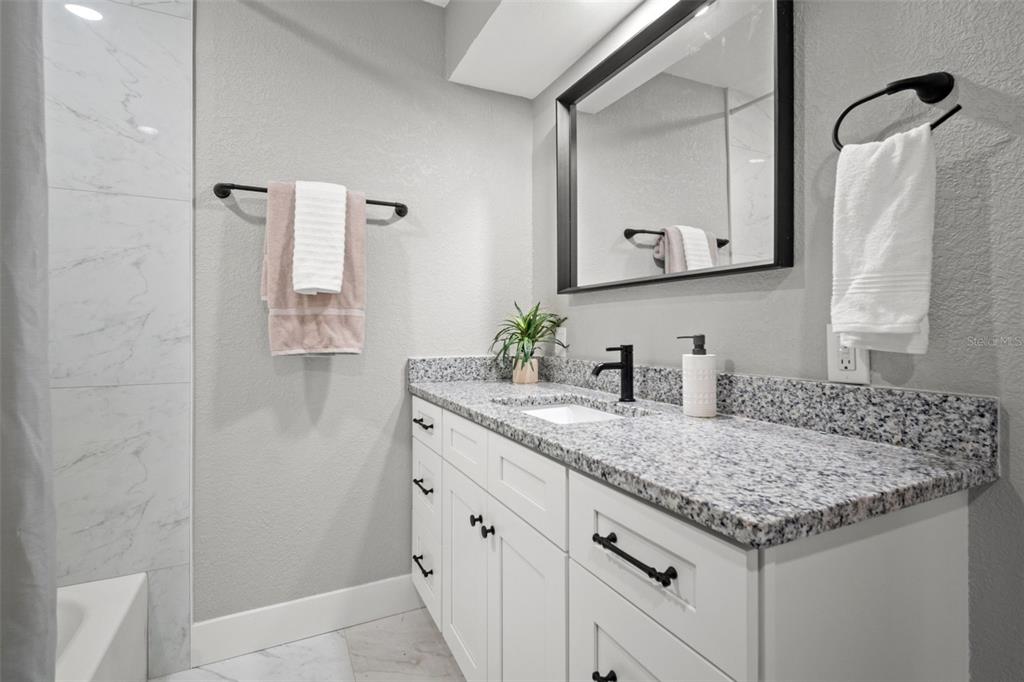1472 Ruth Road Dunedin, FL 34698 - Photo 25 of 50 a bathroom with a granite countertop sink and a mirror