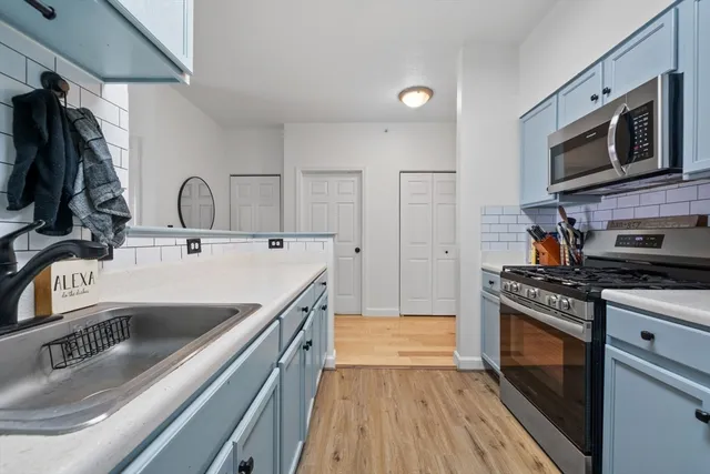 a kitchen with kitchen island a stove top oven a sink a dining table and chairs