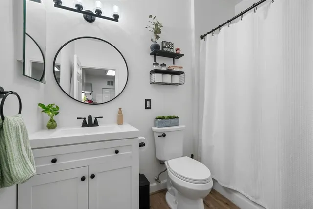 a bathroom with a toilet a sink and a mirror