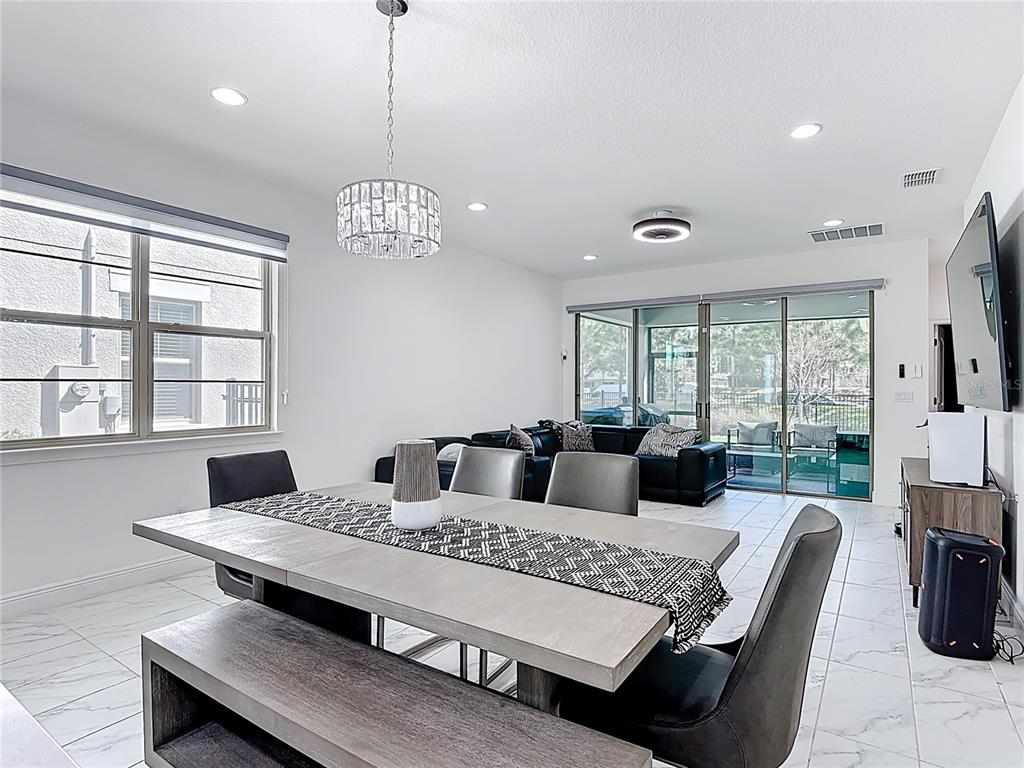 7541 Wing Span Way Harmony, FL 34773 - Photo 12 of 49 a living room with couch a dining table and a large window