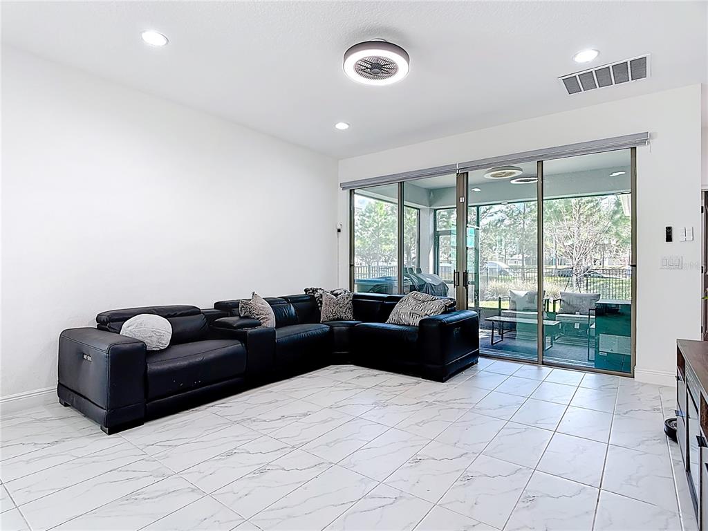 7541 Wing Span Way Harmony, FL 34773 - Photo 15 of 49 a living room with furniture and a floor to ceiling window