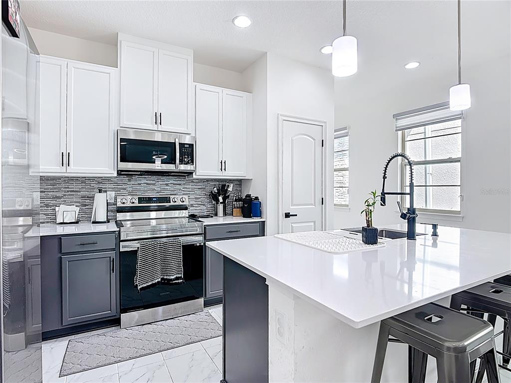 7541 Wing Span Way Harmony, FL 34773 - Photo 5 of 49 a kitchen with a stove a sink and a refrigerator