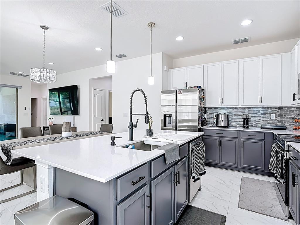 7541 Wing Span Way Harmony, FL 34773 - Photo 7 of 49 a kitchen with sink stove and white cabinets