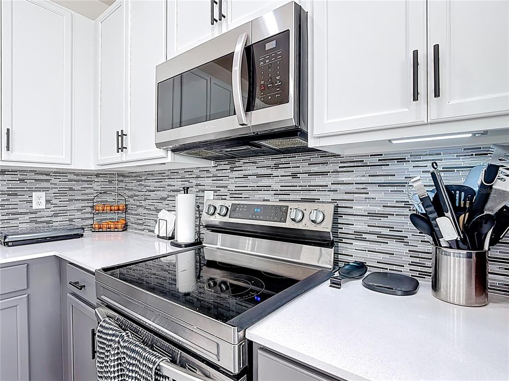 7541 Wing Span Way Harmony, FL 34773 - Photo 9 of 49 a kitchen with stainless steel appliances granite countertop a stove and a microwave