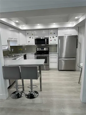 a kitchen with a refrigerator and a stove top oven