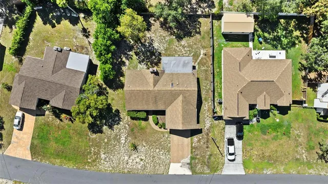 an aerial view of a house with a yard and large tree