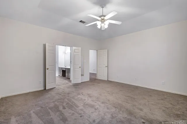 an empty room with chandelier fan