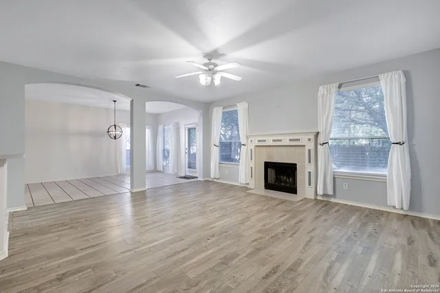 a view of a livingroom with a fireplace ceiling fan and window