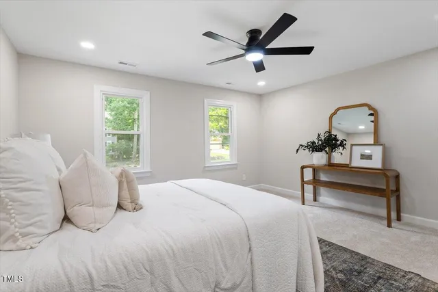a bedroom with a bed a window and a chandelier
