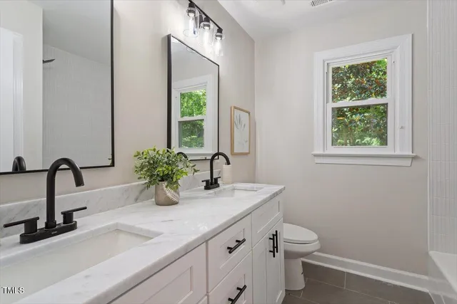 a bathroom with a sink a toilet and a window