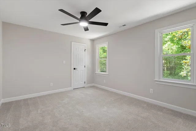 an empty room with a window and a fan