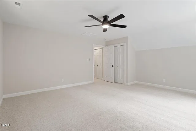 an empty room with closet and windows