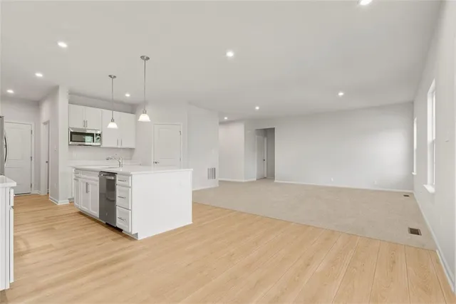 a large kitchen with stainless steel appliances kitchen island a large counter top and a stove top oven