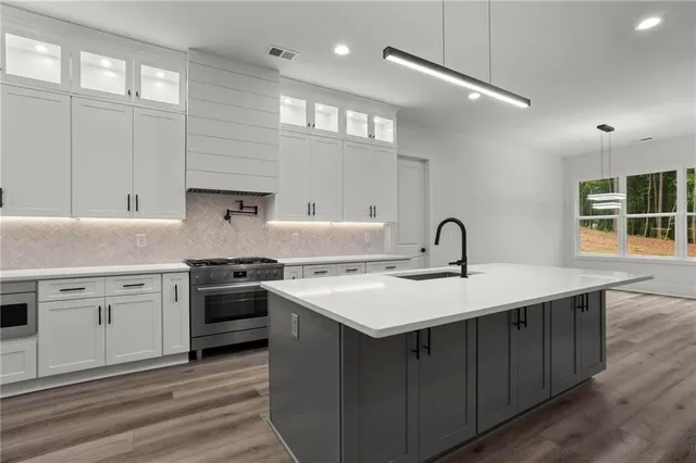 a kitchen with a sink appliances and cabinets
