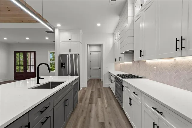 a kitchen with granite countertop a sink stainless steel appliances and cabinets