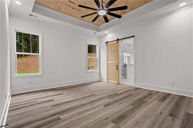 a view of an empty room with window and wooden floor