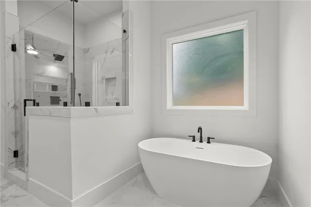 a white bath tub sitting next to a bathroom sink