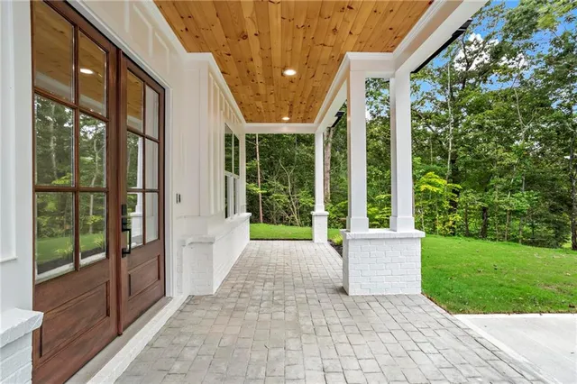 a porch with seating space and garden view
