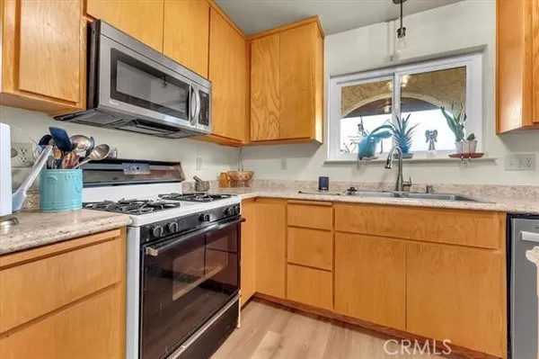 a kitchen with stainless steel appliances granite countertop a sink stove and microwave