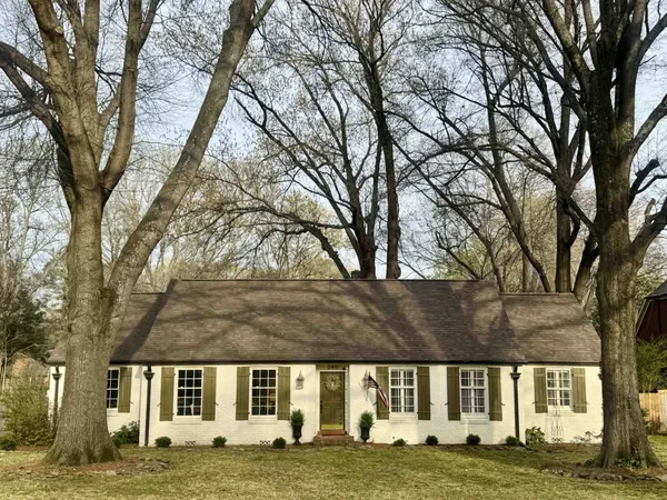 a view of building with yard and trees in the background