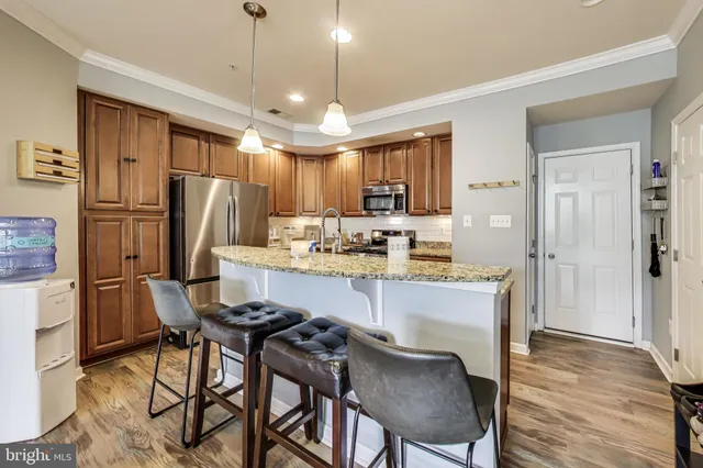 a kitchen with refrigerator a sink and chairs