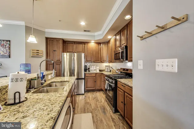 a kitchen with stainless steel appliances granite countertop a refrigerator stove microwave and sink