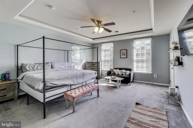 a bedroom with a bed a couch and a chandelier