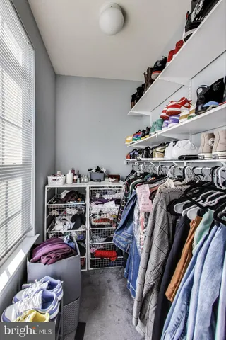 a view of walk in closet with clothes and shoes